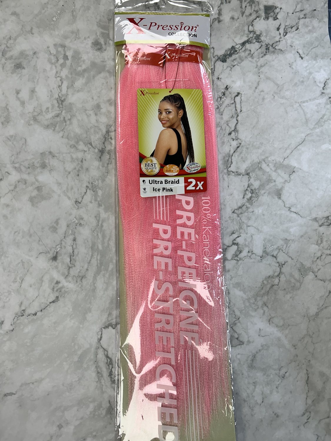 A pack of pink pre-stretched braiding hair from the shop, on a marble counter